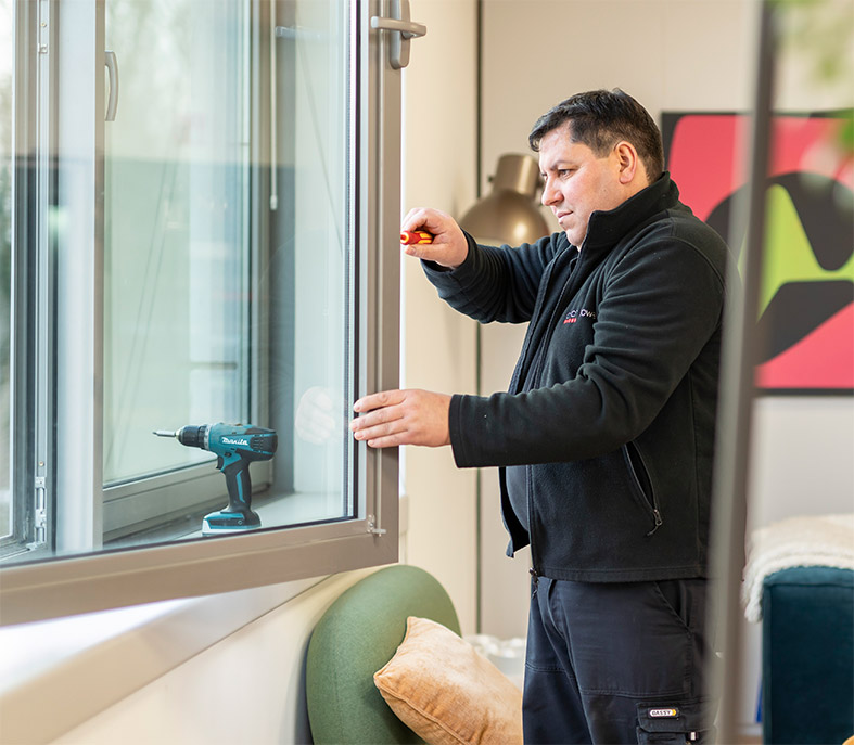 Handyman en train de réparer une fenêtre dans un bureau.