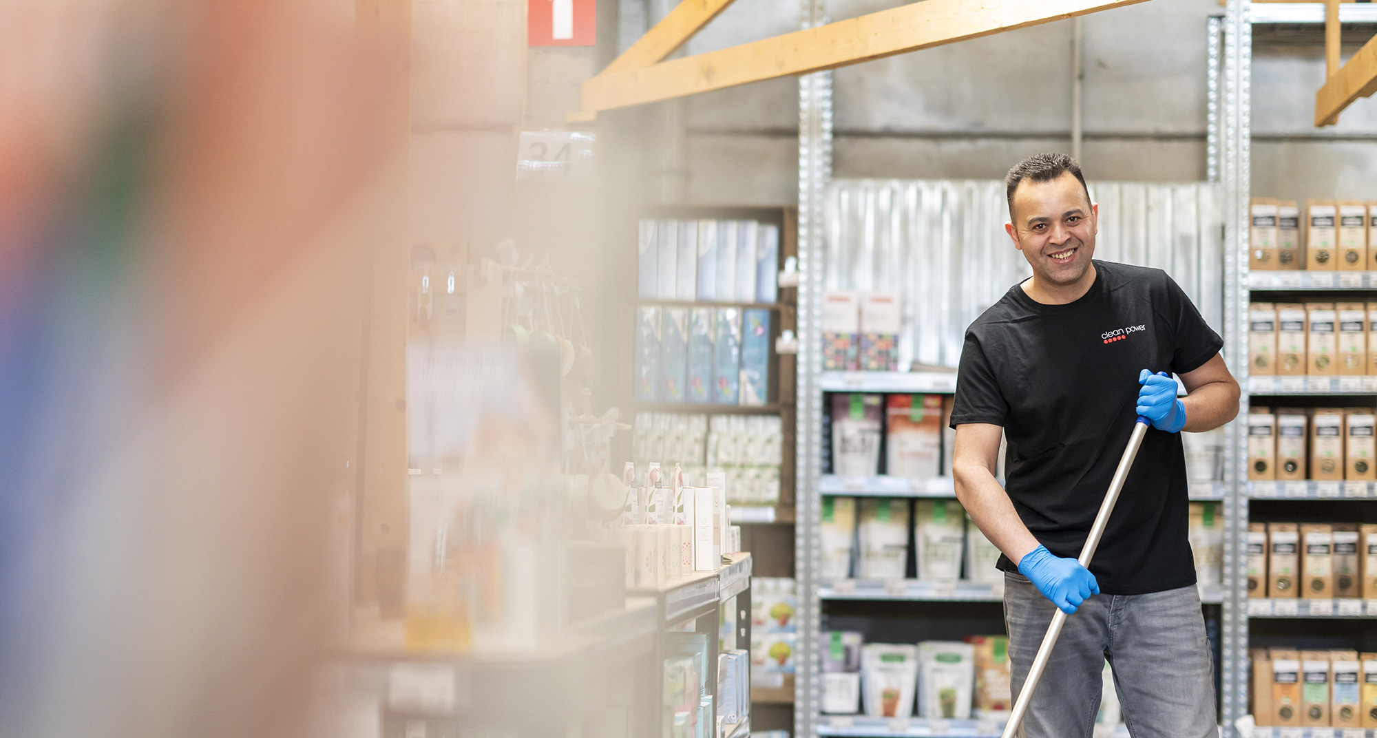 Homme souriant en train de nettoyer dans un magasin alimentaire.