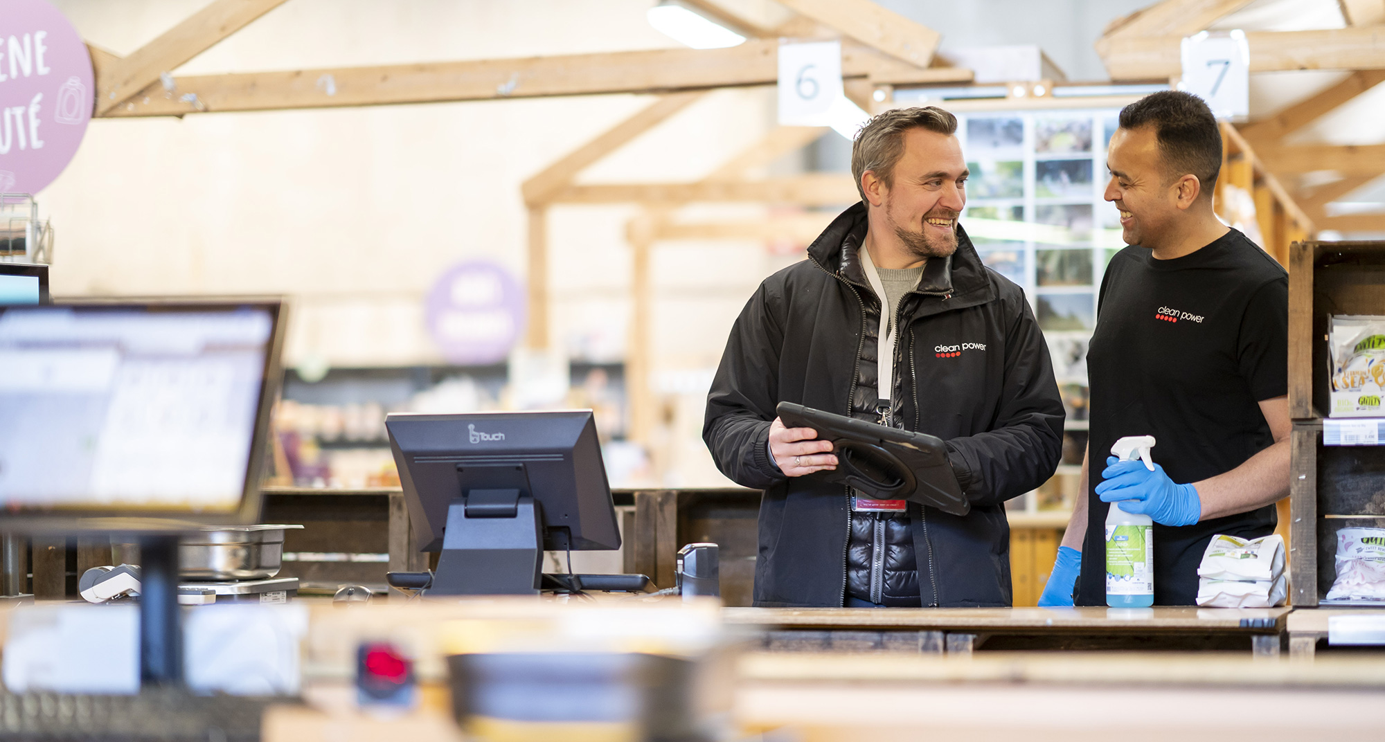 Deux membres du personnel qui rigolent ensemble dans un magasin.
