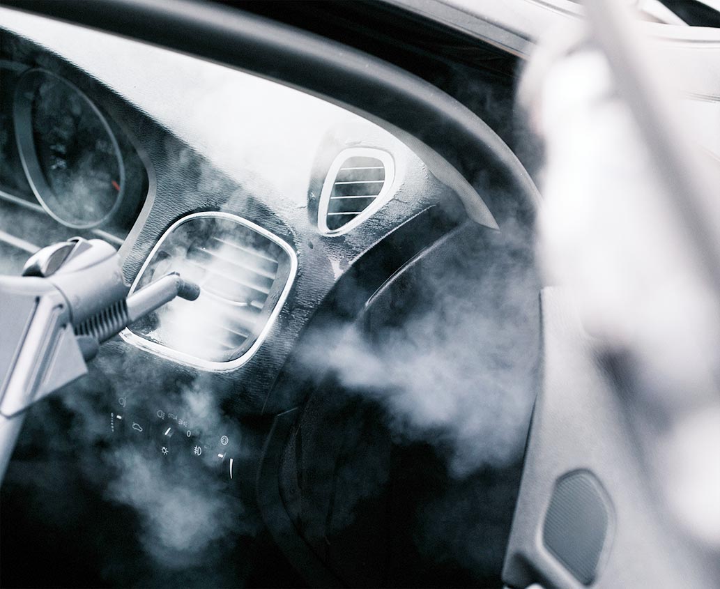 Nettoyage à la vapeur de l’intérieur d’une voiture dans une concession automobile.
