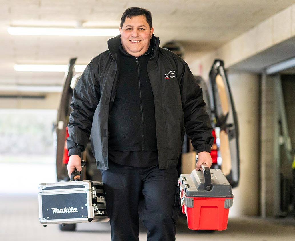 Handyman de Clean Power tenant une boite à outils dans chaque main dans une société.