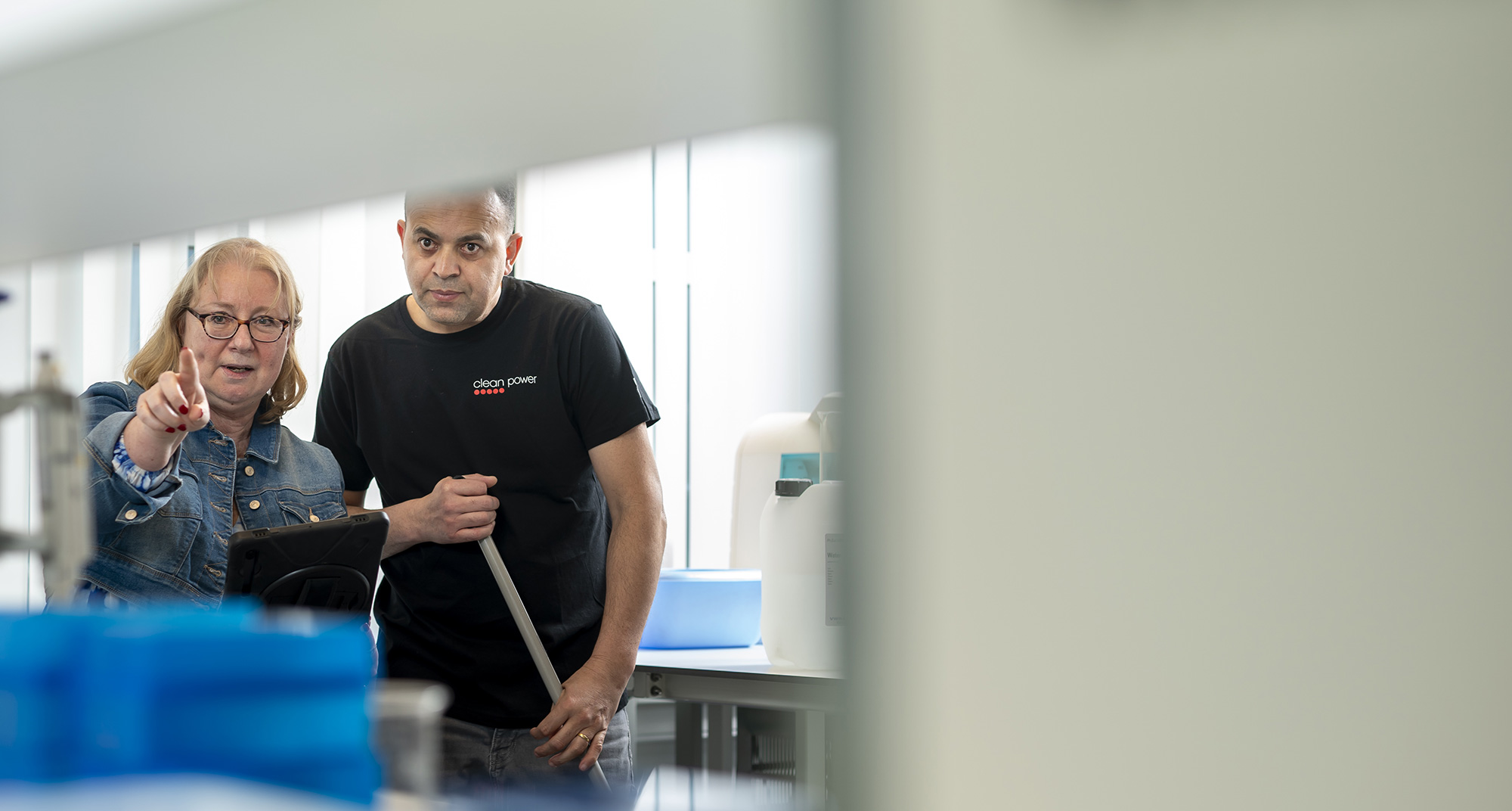 Manager expliquant les consignes de nettoyage à un membre du personnel dans un laboratoire.