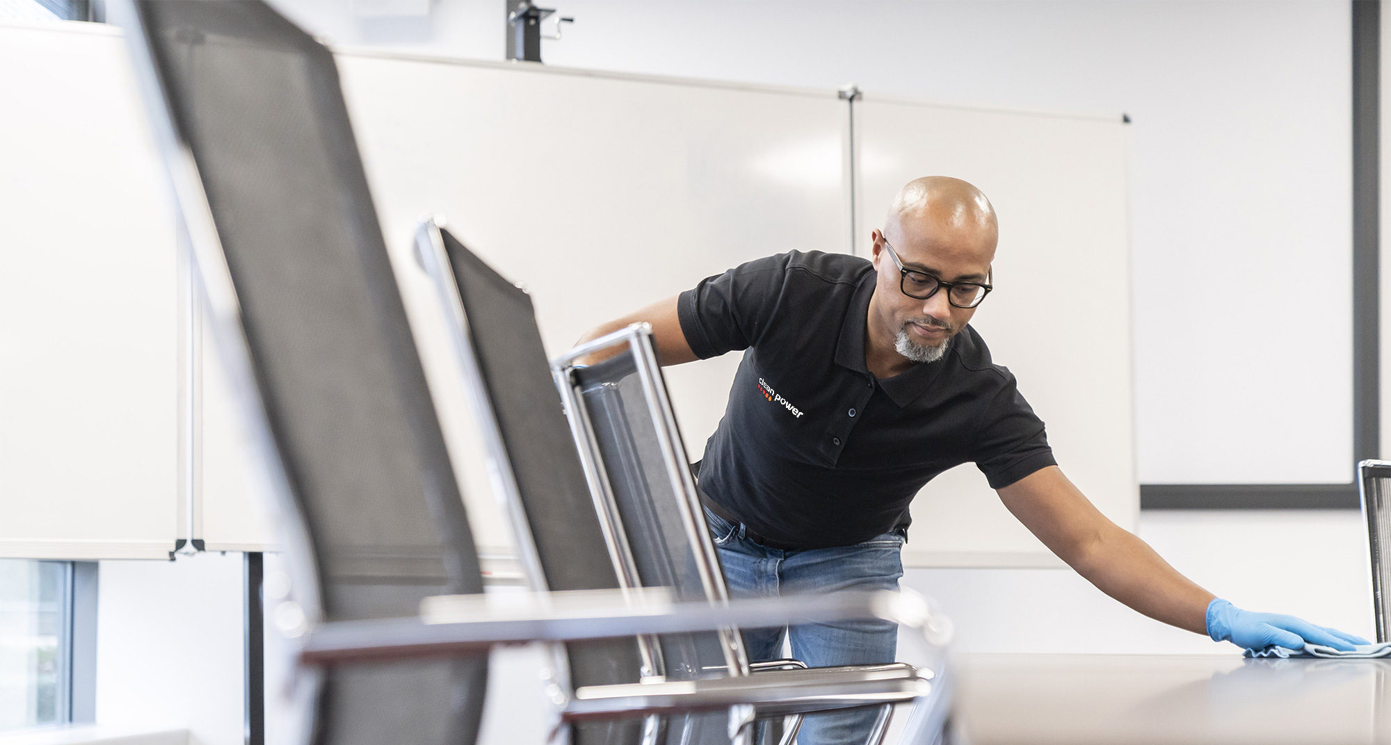 Professionnel nettoie la table d’une salle de réunion dans un bureau.
