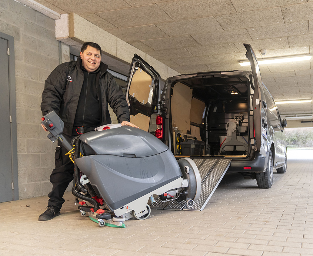 Handyman prépare une autolaveuse à l’arrière d’une camionnette.